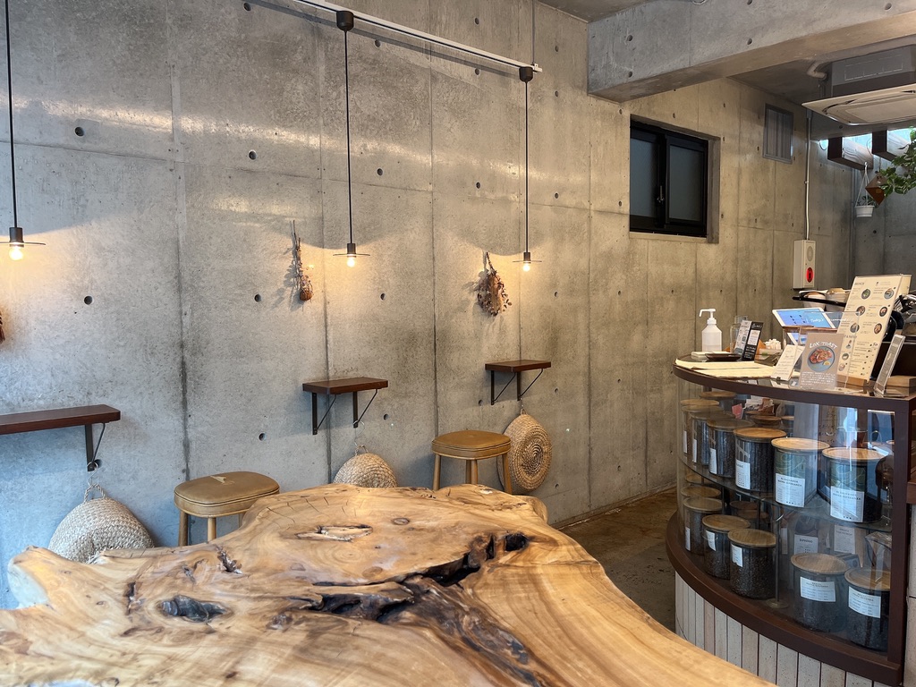 打ちっぱなしの壁と観葉植物が印象的なWOODBERRY COFFEE学芸大学店の店内。